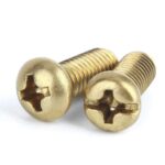 Deux vis à tête cruciforme en laiton sur fond blanc