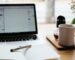 Espace de travail avec ordinateur portable et carnet de notes, illustrant l'apprentissage en ligne et la formation continue